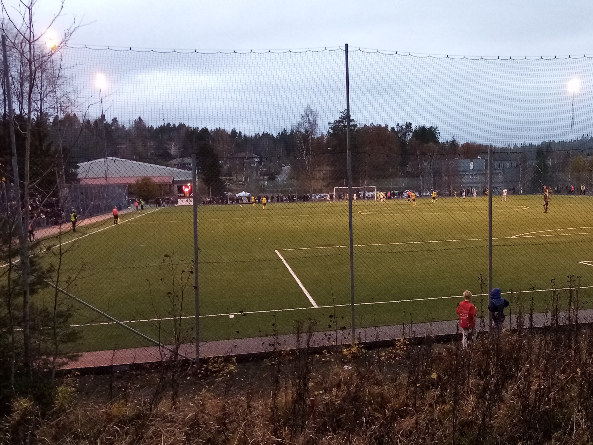 Där borta i fjärran på Källbrinks konstgräs jagar vi förgäves mål i slutskedet av kvalmatchen mot Fittja IF.